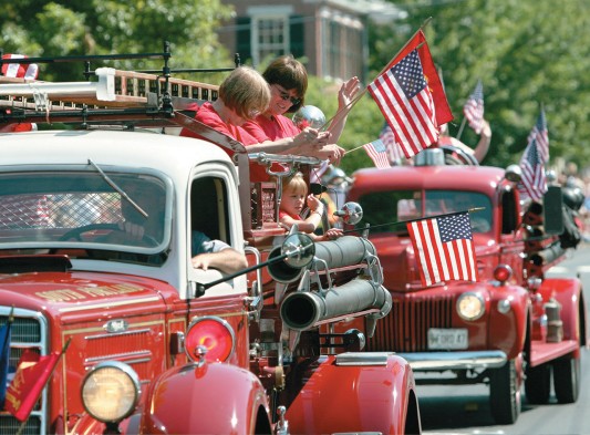 Antique fire trucks participate in the annual July Fourth holiday parade on Main Street in Freeport, Maine