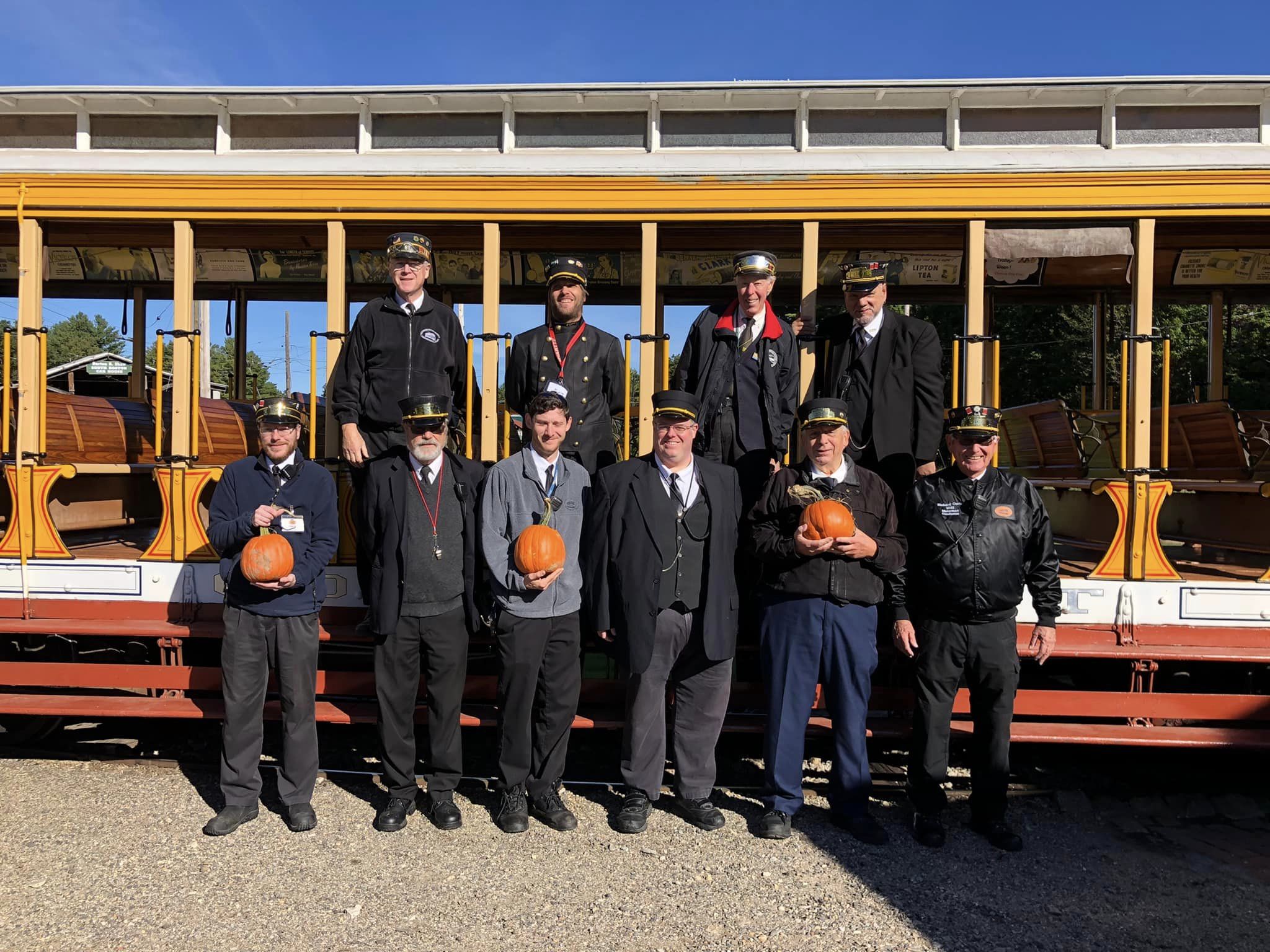 Conductors stand in front of the Pumpkin Patch Trolley Rides at the Seashore Trolley Museum